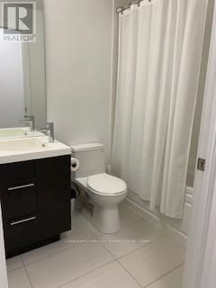 Toronto (Waterfront Communities) condo for rent - A white toilet sits in a bathroom next to a sink.