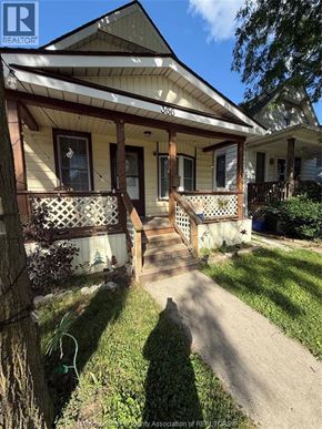 Windsor apartment for rent - A house with a porch and a tree in front of it.