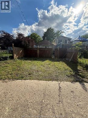 Windsor apartment for rent - A backyard with a fence and a house in the background.