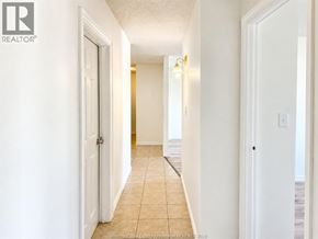 Windsor condo for rent - A hallway with tiled flooring and white walls.