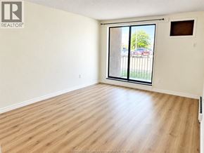 Windsor condo for rent - A room with a sliding glass door leading to a parking lot.