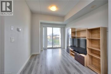 Waterloo condo for rent - A spacious living room with a television and wooden entertainment center.