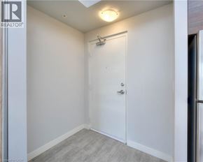 Waterloo condo for rent - A white door in a room with a grey floor.
