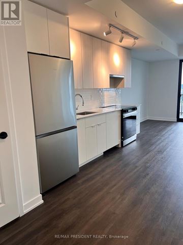 Burlington (Brant) condo for rent - A kitchen with white cabinets and a stainless steel refrigerator.