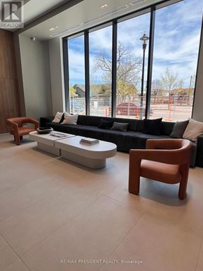 Burlington (Brant) condo for rent - A modern living room with a large window overlooking a construction site.