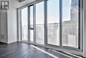 Toronto (Church-Yonge Corridor) condo for rent - A room with a large window and a view of a city skyline.