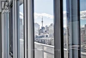 Toronto (Church-Yonge Corridor) condo for rent - A view of a cityscape through a window with a glass door.