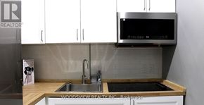 Oshawa (O'neill) apartment for rent - A kitchen with a sink and a microwave above it.