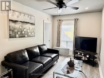 Niagara Falls (Downtown) multi-family for rent - A living room with a black leather couch and a flat screen TV.
