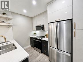 Windsor condo for rent - A modern kitchen with a stainless steel refrigerator and a white countertop.
