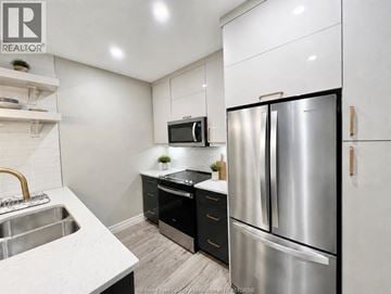 Windsor condo for rent - A modern kitchen with a stainless steel refrigerator and a white countertop.