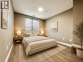 Windsor condo for rent - A bedroom with a large bed and a plant in a pot.