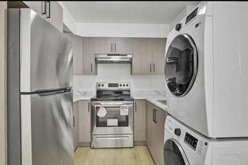 Surrey apartment for rent - A modern kitchen with a stainless steel refrigerator and a white dishwasher.