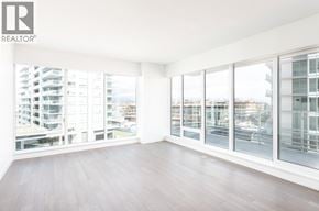 Richmond apartment for rent - A large empty room with a view of the city through the windows.