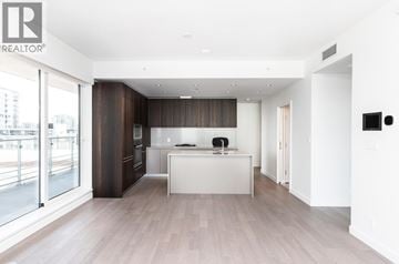 Richmond apartment for rent - A modern kitchen with a white island and wooden floors.
