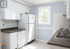 St. Catharines (Western Hill) apartment for rent - A kitchen with white appliances and cabinets.