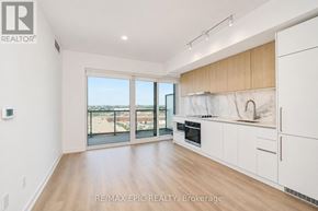 Toronto (York University Heights) condo for rent - A spacious kitchen with white cabinets and a marble backsplash.