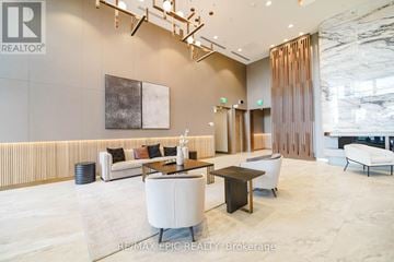 Toronto (York University Heights) condo for rent - A modern living room with a white sofa and a wooden coffee table.