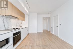 Toronto (York University Heights) condo for rent - A kitchen with white marble countertops and wooden cabinets.
