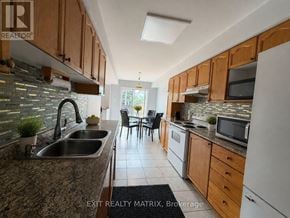 Ottawa townhouse for rent - A kitchen with a sink, stove, and refrigerator.