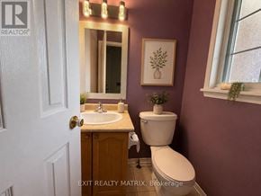 Ottawa townhouse for rent - A bathroom with a toilet, sink, and mirror.