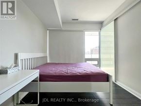 Toronto (Church-Yonge Corridor) condo for rent - A bedroom with a bed, nightstand, and window.