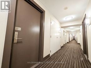 Toronto (Henry Farm) condo for rent - A hallway with a brown door and white walls.
