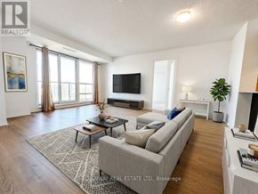 Toronto (Henry Farm) condo for rent - A living room with a grey couch, a coffee table, a flat screen TV, and a large window with curtains.
