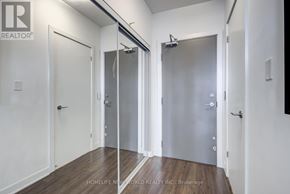 Toronto (Waterfront Communities) condo for rent - A room with white walls and wooden floors, featuring a glass door with a handle and a metal frame.