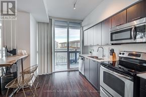 Toronto (Waterfront Communities) condo for rent - A modern kitchen with a wooden floor and stainless steel appliances.