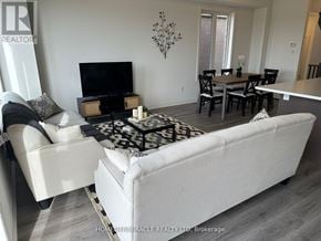 Barrie townhouse for rent - A living room with a white couch and a black television.