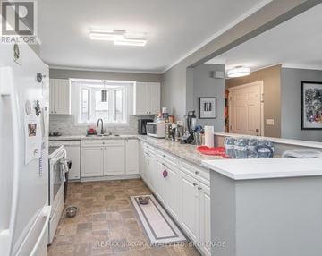 St. Catharines (Carlton/Bunting) apartment for rent - A kitchen with white cabinets and a tiled floor.