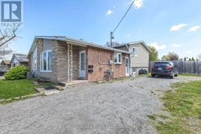 St. Catharines (Carlton/Bunting) apartment for rent - A house with a gravel driveway and a car parked in front.