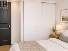 Toronto (Niagara) condo for rent - A bedroom with a bed, nightstand, and a door.