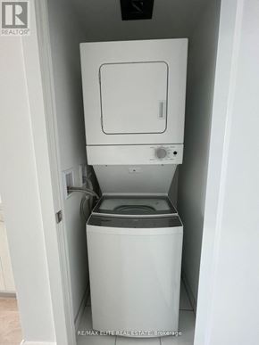Oshawa (Windfields) condo for rent - A white washing machine and dryer in a small laundry room.