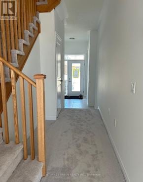 Centre Wellington (Fergus) townhouse for rent - A hallway with a staircase on the left and a door on the right.