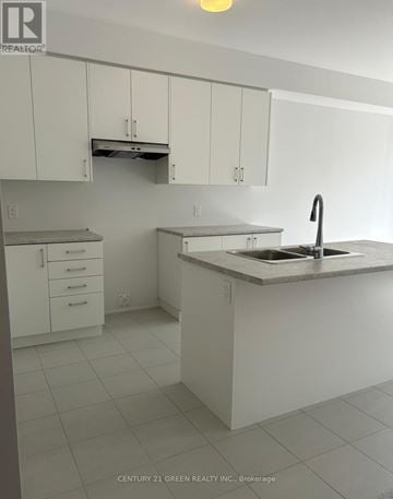 Centre Wellington (Fergus) townhouse for rent - A kitchen with white cabinets and a sink.