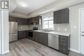 Welland (Lincoln/Crowland) fourplex for rent - A kitchen with a refrigerator, sink, and cabinets.