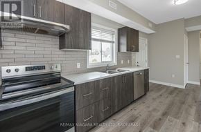 Welland (Lincoln/Crowland) fourplex for rent - A modern kitchen with dark wood cabinets and stainless steel appliances.