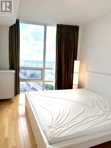 Toronto (Bendale) condo for rent - A bedroom with a large bed and a view of the city.