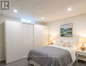 East Gwillimbury (Holland Landing) apartment for rent - A bedroom with a bed, two lamps, and a painting on the wall.