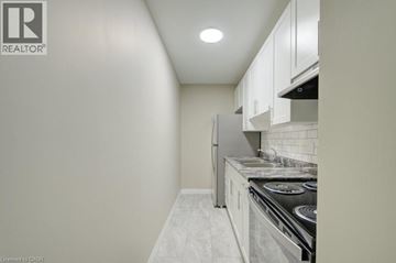Cambridge apartment for rent - A small kitchen with white cabinets and a stove top oven.