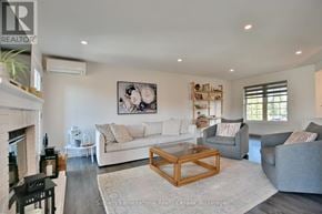 Blue Mountains townhouse for rent - A living room with a fireplace and a painting on the wall.