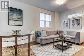 Toronto (The Beaches) apartment for rent - A living room with a grey couch, a glass table, and a painting on the wall.