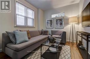 Toronto (The Beaches) apartment for rent - A living room with a grey couch, a glass coffee table, and a lamp.