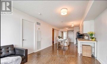 Toronto (Bayview Village) condo for rent - A living room with a black leather couch and a dining area with a white table and chairs.