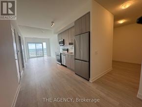 Pickering (Bay Ridges) condo for rent - A spacious kitchen with a refrigerator, microwave, and dishwasher.