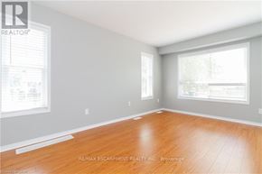 Hamilton (Binbrook) townhouse for rent - A room with wooden flooring and two windows.