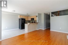 Hamilton (Binbrook) townhouse for rent - A kitchen area with a black fridge and microwave, and a wooden countertop.