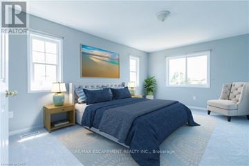 Hamilton (Binbrook) townhouse for rent - A bedroom with a large bed and a painting on the wall.